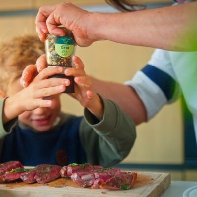 Kind würzt Fleisch