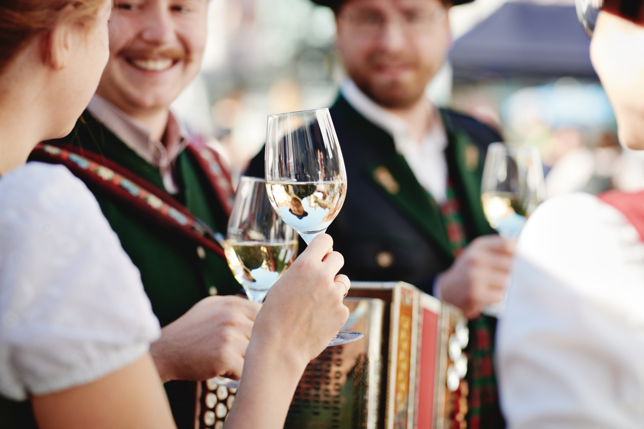 Personen stoßen mit Weingläsern an