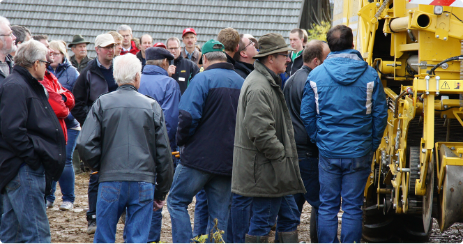 Menschengruppe vor Kartoffelroder