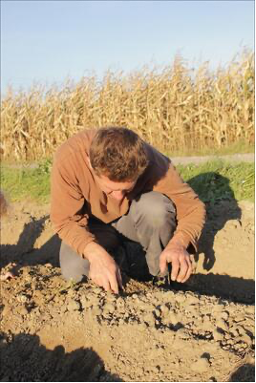 mann untersucht Boden auf Acker