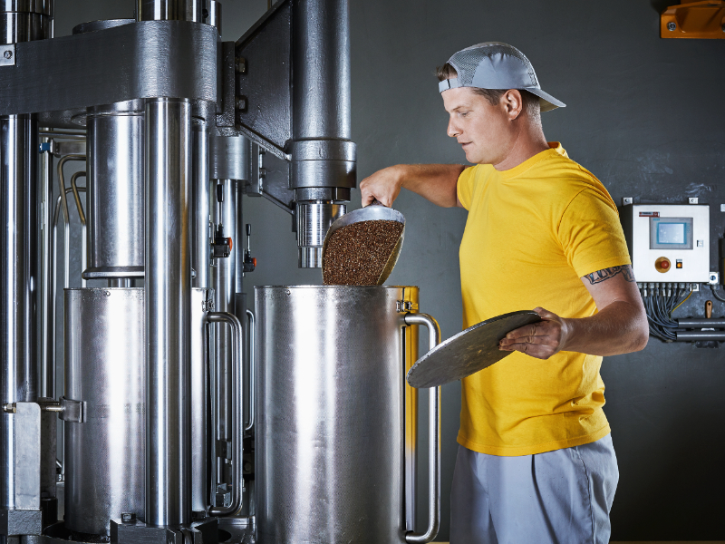 Mitarbeiter mit Ölpresse bei der Ölmühle Fandler