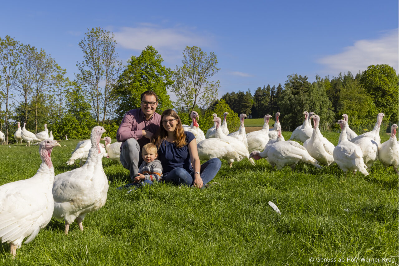 Bauernfamilie mit Bio-Puten auf Wiese