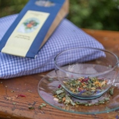 Glasstasse mit getrockneten und zerkleinerten Kräutern